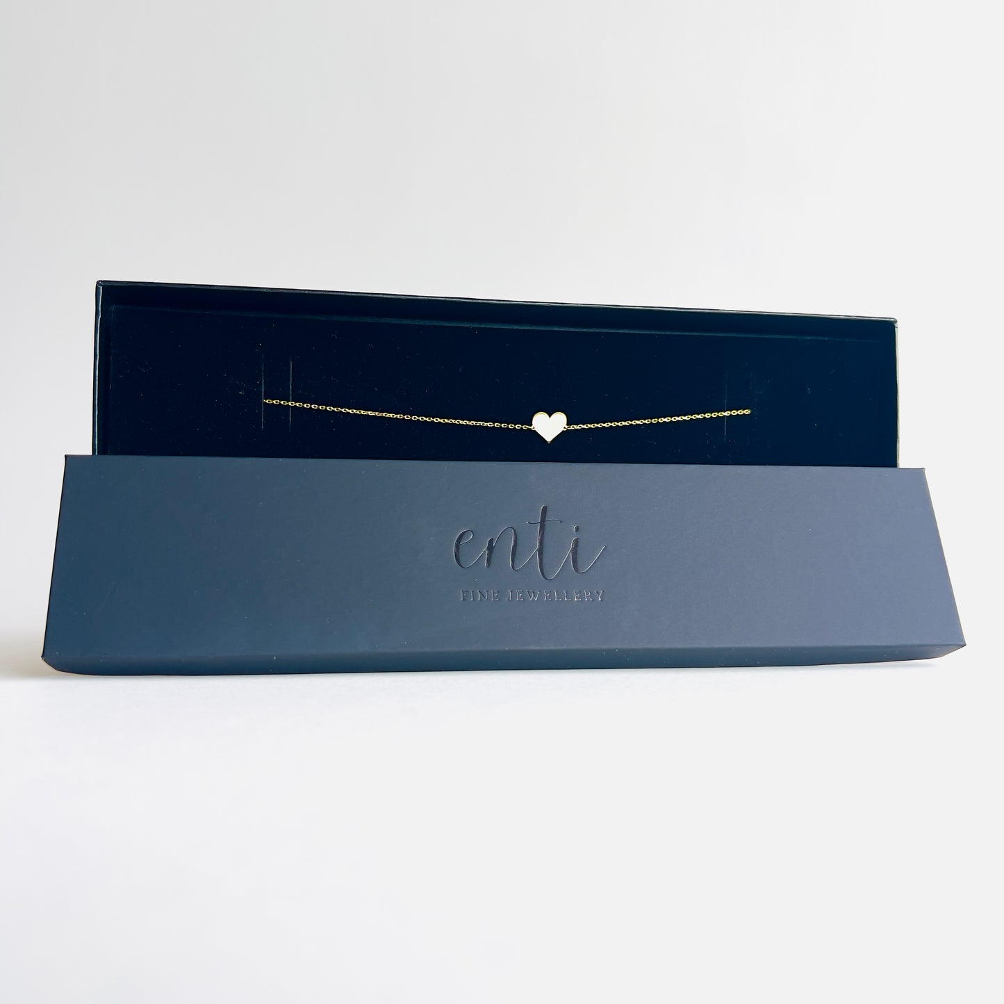 Enti Jamila necklace, handmade in 18k gold with a delicate heart pendant and gold chain, presented in the signature Enti Jewellery box