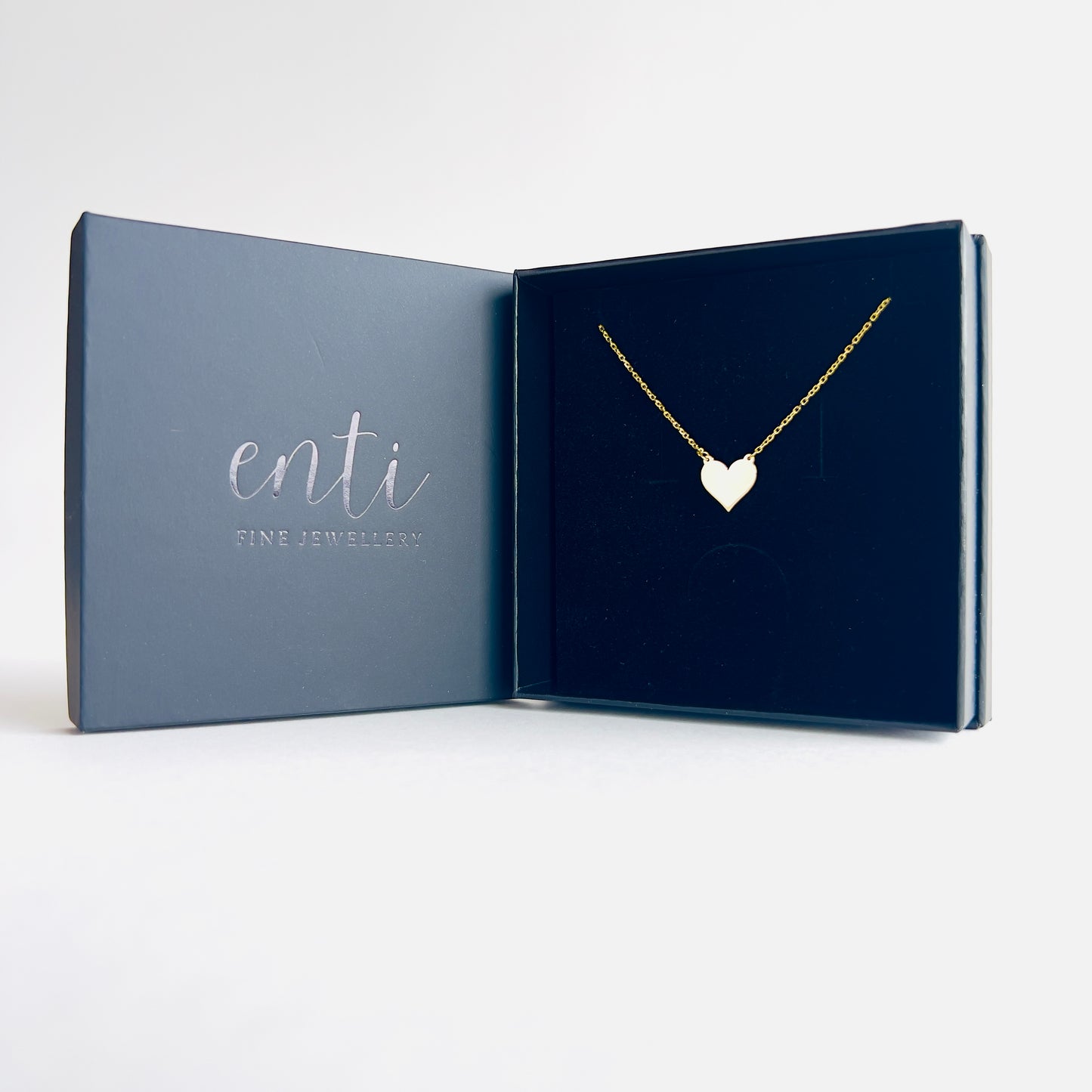 Enti Jamila necklace, handmade in 18k gold with a delicate heart pendant and gold chain, presented in the signature Enti Jewellery box.