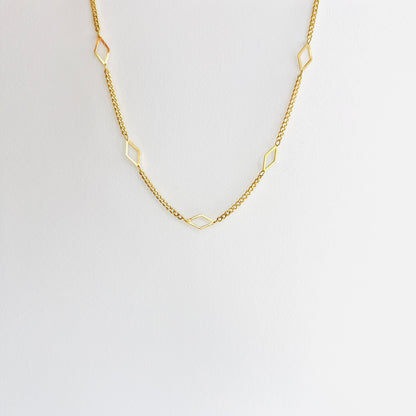 Enti Leila necklace, handmade in 18k gold with a sleek diamond-shaped geometric pendant and gold chain, displayed on white background