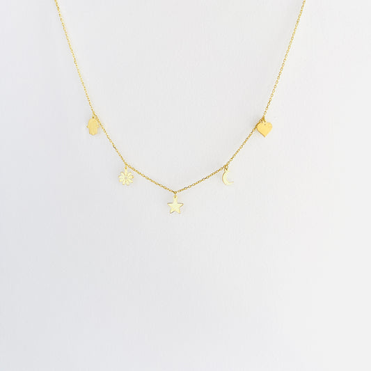 Enti Lina necklace, handmade in 18k gold with delicate charms including a heart, moon, star, flower, and hand of fatima on a gold chain, displayed on white background