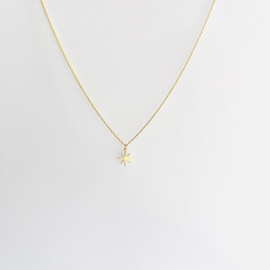 Enti Najma necklace, handmade in 18k gold with a delicate star pendant and gold chain, displayed on white background