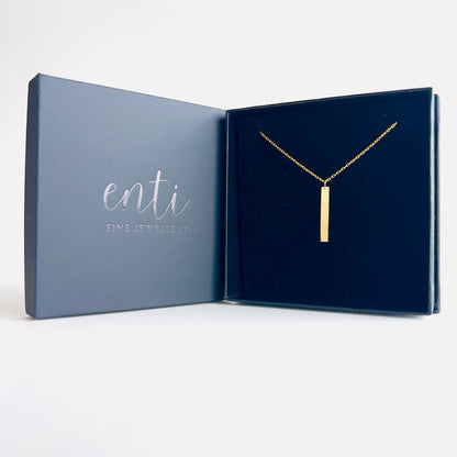 Enti Zara necklace, handmade in 18k gold with a sleek bar pendant, presented in the signature Enti Jewellery box